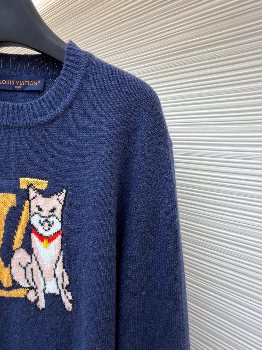 LOUIS VUITTON Seoul-limited intarsia knitted sweater ●Original version: purchased and developed by 11599 ●Item number: 1682133-B85 ●Fabric: wool blended fabric ●Technology: knitted intarsia production ●Color: blue ●Version: fitted version ●Weight: about 535 grams ●Size: S-M-L-XL ●Description: This Louis Vuitton navy blue knitted sweater is woven with 100% ultra-fine merino wool yarn. The basic gray cloth is knitted by a 14-needle precision knitting machine in the Italian workshop. The yarn is first pre-washed and milled to ensure that the garment is not easy to deform, pilling and has excellent skin-friendly properties. The iconic LV letters and Shiba Inu pattern on the front are made using intarsia jacquard technology. Imported acrylic and wool blended threads with high color fastness are used, and are woven needle by needle through a computer-controlled jacquard machine. There are no skipping or floating thread problems on the edges of the pattern. The colors are clearly layered and have a strong three-dimensional effect; the collar and cuffs Both the hem and the hem are made of double-rib hemming technology, with spandex elastic yarn, which has good resilience and is not easy to loosen after long-term wear. The entire body of the garment is hand-ironed and shaped. Every stitching follows the brand's strict 0.1cm stitch length standard, and the details show the exquisite texture of high-end knitting technology. The overall wiring is straight and delicate, the fabric is comfortable and soft, and the color is consistent without color difference. It can be matched with the same style to create a fashionable look and control various occasions. Customized accessories, complete with three standards, same style for men and women!